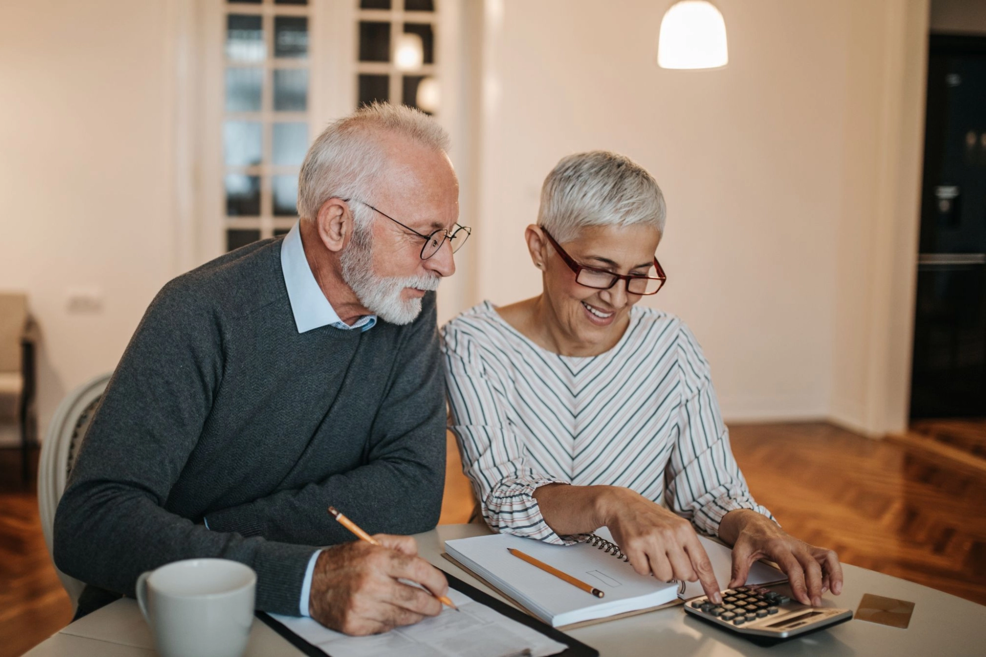 älteres Paar benutzen einen Taschenrechner